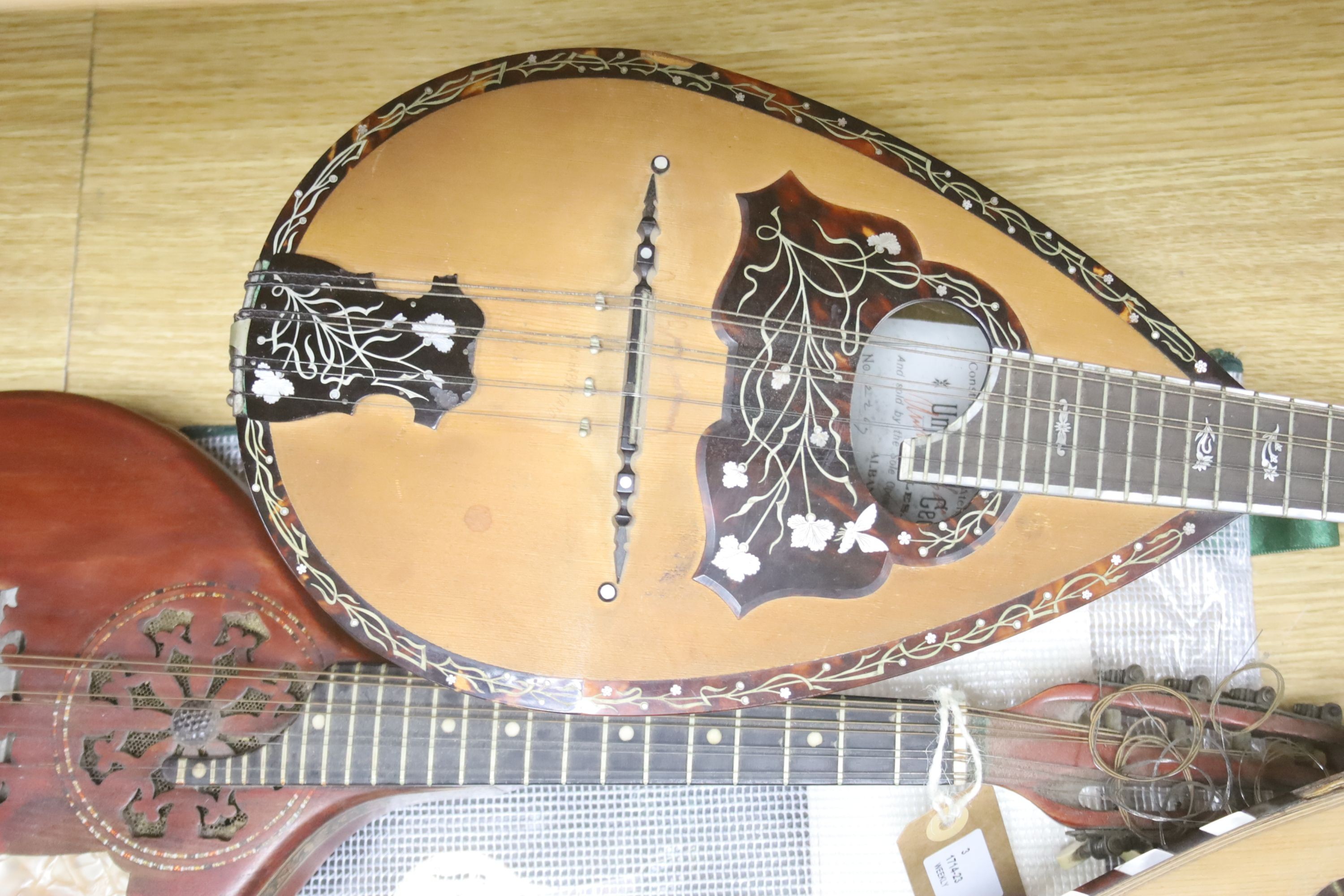 Three Neapolitan mandolins with inlaid mother of pearl decoration, one of round-backed form, the other two archtop